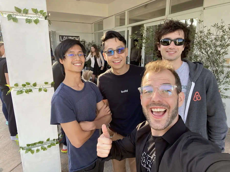 Matthew taking a selfie with three builders outside Launch House.