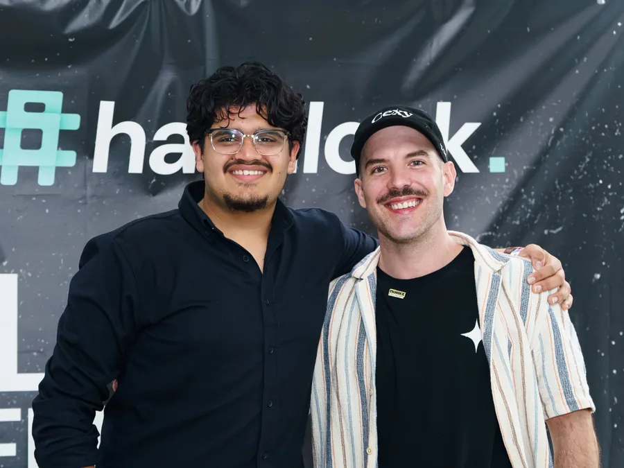 Matthew with a fellow builder in front of a Hashlock backdrop.